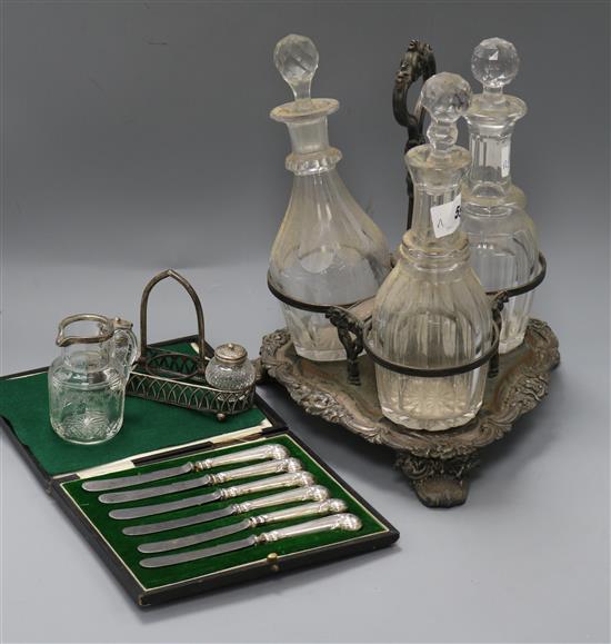 A Victorian silver plated decanter stand, silver cruet jug and knives